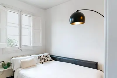 a bedroom with a bed and a black lamp at Alma Azul Consell de Cent in Barcelona