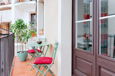 a balcony with a table and chairs and a door at Alma Azul Consell de Cent in Barcelona