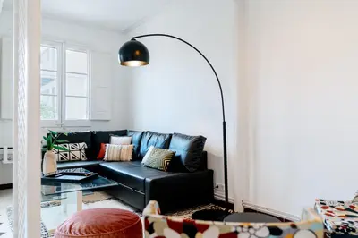 a living room with a black leather couch at Alma Azul Consell de Cent in Barcelona