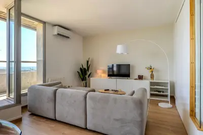 a living room with a couch and a tv at AB Olympic Village III Penthouse in Barcelona