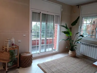a living room with a large window and a plant at Villa Brisas - Preciosa villa con gran intimidad y piscina in Segur de Calafell