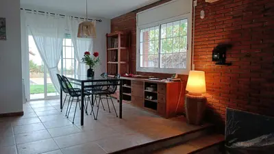 a kitchen with a table and chairs and a brick wall at Villa Brisas - Preciosa villa con gran intimidad y piscina in Segur de Calafell