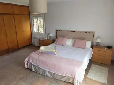 a bedroom with a large bed with pink pillows at Villa Brisas - Preciosa villa con gran intimidad y piscina in Segur de Calafell