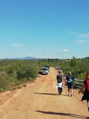 a group of people walking down a dirt road at L'Olivera Casa Rural in Castellbisbal