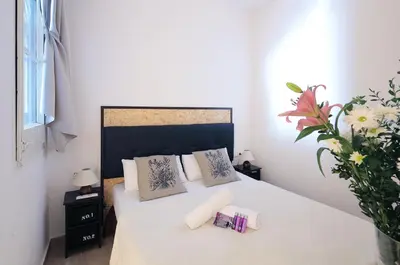 a bedroom with a white bed with two pillows at Hostal Balkonis in Barcelona
