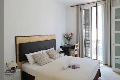 a bedroom with a large bed with a large window at Hostal Balkonis in Barcelona