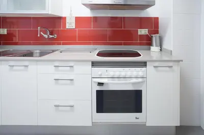 a white kitchen with a stove and a sink at Bordeta in Barcelona