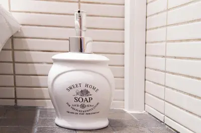a white bottle of sweet honey soap sitting on a floor at Bordeta in Barcelona