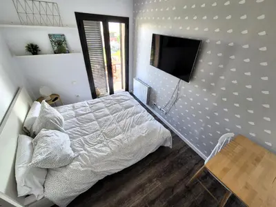 a bedroom with a bed and a flat screen tv at Casa Elena Maresme in Mataró