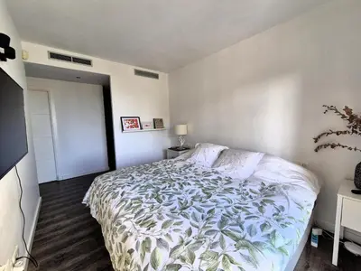 a bedroom with a bed with a white comforter at Casa Elena Maresme in Mataró