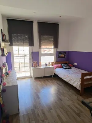 a bedroom with a large bed with purple walls at Precioso Dúplex con terraza a 5 minutos playa y 20 minutos de Barcelona in Premiá de Mar