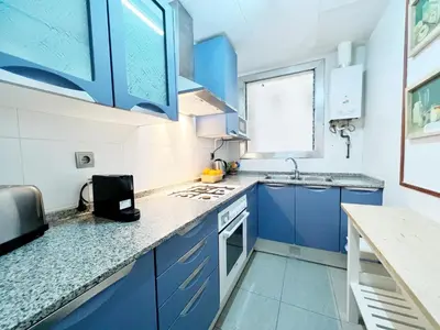 a blue and white kitchen with blue cabinets and a sink at Casa Sagrada Familia in Barcelona