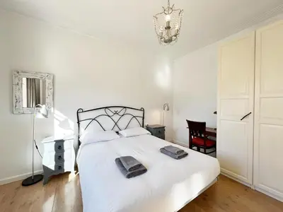 a bedroom with a white bed and a chandelier at Casa Sagrada Familia in Barcelona