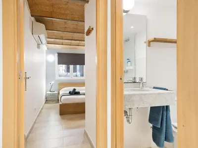 a bathroom with a sink and a bedroom at Duplex Sagrada Familia 1 in Barcelona