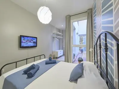a bedroom with a bed and a tv and a window at Duplex Sagrada Familia 2 in Barcelona