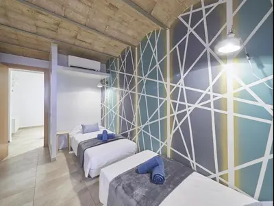 a room with three beds and a wall with triangles at Duplex Sagrada Familia 2 in Barcelona