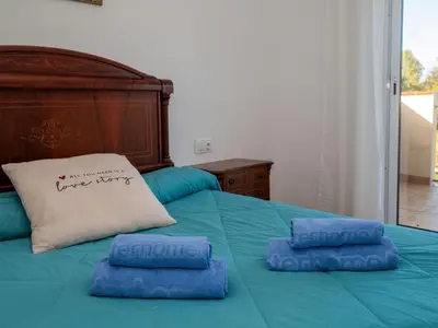 a bed with two blue pillows on top of it at Holiday Home Origin by Interhome in Olivella