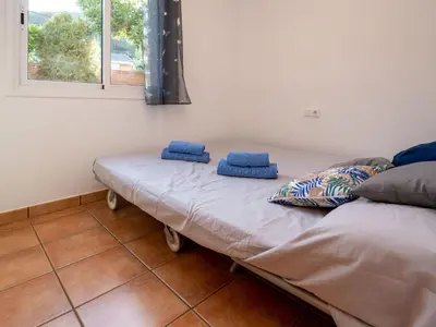 two beds sitting in a room with a window at Holiday Home Origin by Interhome in Olivella