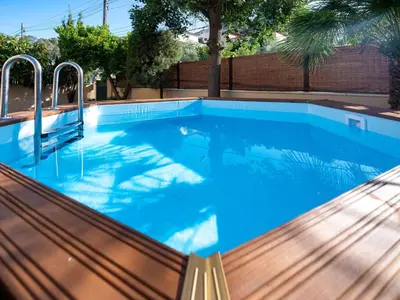 a swimming pool with blue water and a bench at Holiday Home Origin by Interhome in Olivella