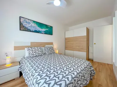 a bedroom with a bed and a tv on the wall at Vivalidays Vianka - Pineda de Mar in Pineda de Mar