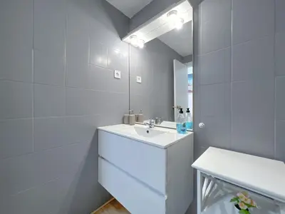 a white bathroom with a sink and a mirror at Vivalidays Vianka - Pineda de Mar in Pineda de Mar