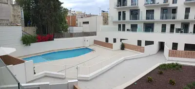 a swimming pool in the middle of a building at New beside Sitges with pool beside beach in Vilanova i la Geltrú