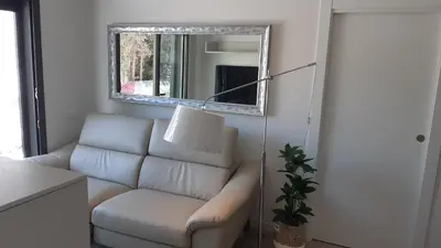 a living room with a couch and a mirror at New beside Sitges with pool beside beach in Vilanova i la Geltrú