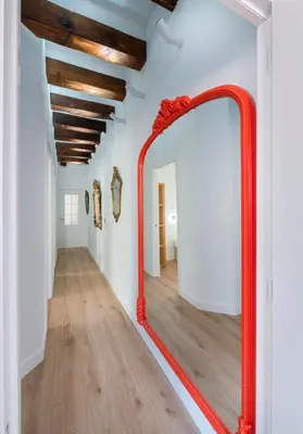 a red mirror in the hallway of a house at Ramblas Waterfront Stay in Barcelona