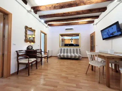 a living room with a table and chairs at Ramblas Waterfront Stay in Barcelona