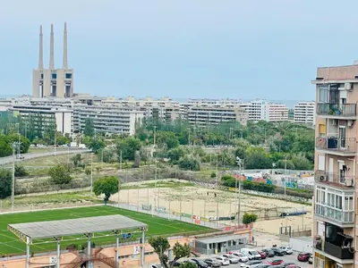a tennis court in a city with a parking lot at Barca 5 NEW BEACH APARTMENT in Sant Adria de Besos