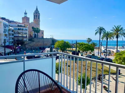 a balcony with a view of a beach and a building at Paradise Apartment by Hello Homes Sitges in Sitges