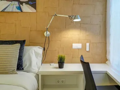 a bedroom with a bed and a desk with a lamp at Paradise Apartment by Hello Homes Sitges in Sitges