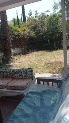 two beds on a porch with a garden in the background at Apartamento - jardín en playa San Sebastian in Sitges