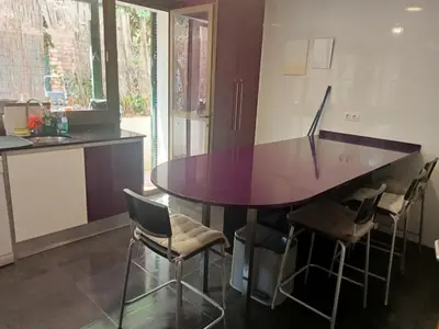a kitchen with a purple table and chairs at Apartamento - jardín en playa San Sebastian in Sitges