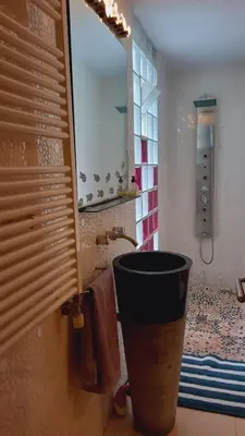 a bathroom with a large mirror and a sink at Apartamento - jardín en playa San Sebastian in Sitges