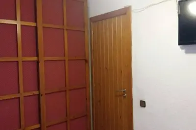 a wooden door in a room with a red wall at Apartamento - jardín en playa San Sebastian in Sitges