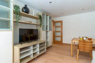 a living room with a table and a television at AB San Mariano - Park Guell in Barcelona