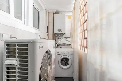 a laundry room with a washing machine and a washer at AB San Mariano - Park Guell in Barcelona