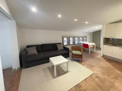 a living room with a black couch and a table at SG Apartamento céntrico ático in Terrassa