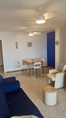 a living room with a table and chairs and a couch at Canet playa y centro con free wifi in Canet de Mar
