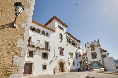 a large white building with a clock tower next to it at Centro Sitges in Sitges