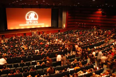 a large crowd of people in an auditorium at Centro Sitges in Sitges
