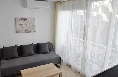 a living room with a couch and a sliding glass door at Centro Sitges in Sitges