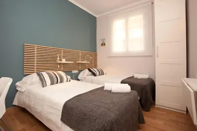 two beds in a room with blue walls and a window at Enjoy Apartments VP Camp Nou 2 in Barcelona