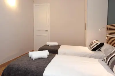 two beds in a room with white walls at Enjoy Apartments VP Camp Nou 2 in Barcelona