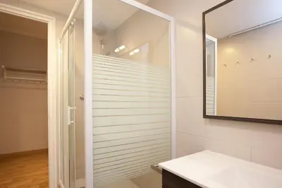a bathroom with a shower and a mirror at Enjoy Apartments VP Camp Nou 2 in Barcelona