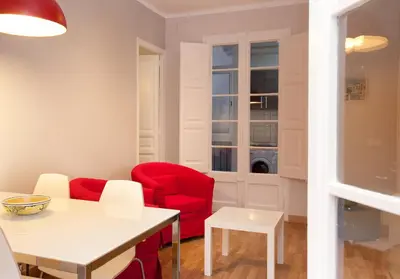 a living room with red chairs and a table at Enjoy Apartments VP Camp Nou 2 in Barcelona