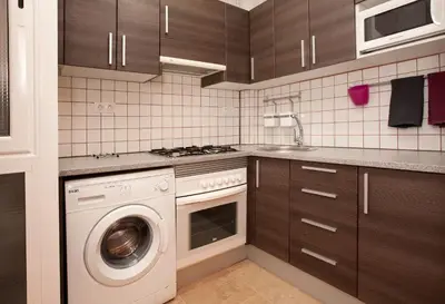 a kitchen with a washing machine and a sink at Enjoy Apartments VP Camp Nou 2 in Barcelona