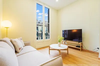 a living room with a white couch and a tv at Flateli Pelayo H6 in Barcelona