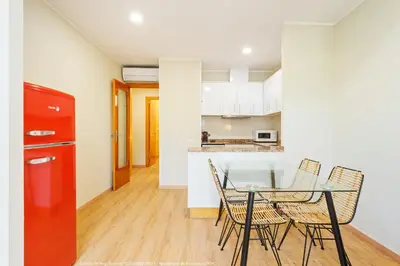 a kitchen and dining room with a glass table and chairs at Flateli Pelayo H6 in Barcelona